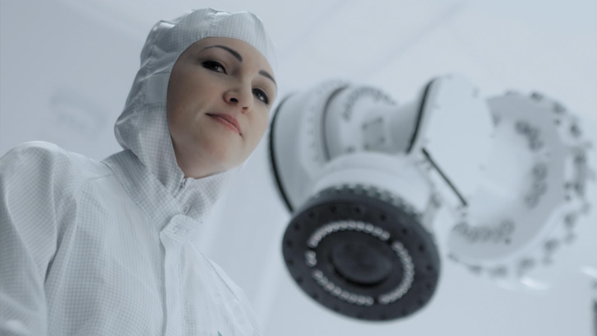 Ausschnitt aus dem Fraunhofer Recruitingspot, eine Frau in Schutzanzug steht vor einer Maschine
